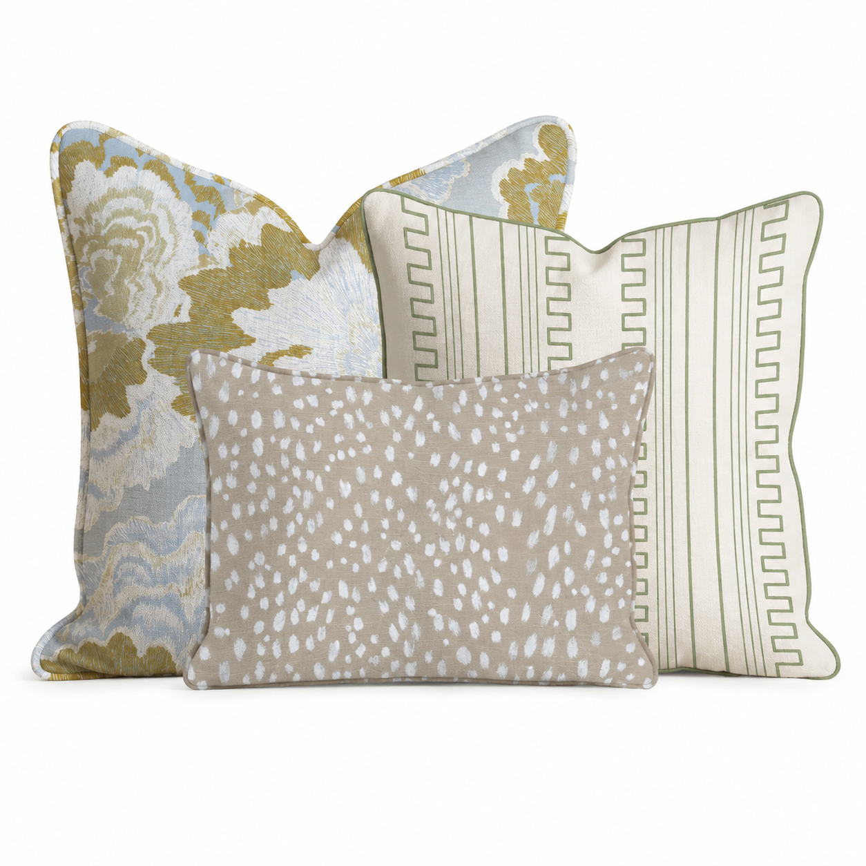 The Abstract Annie Trio Throw Pillow Bundle by Hillcroft Home features three decorative pillows: one with a green and gold floral motif, another with a geometric green and white pattern, and a smaller beige pillow adorned with delicate white speckles, all arranged against a white background.