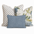 The Hillcroft Home Birdie Floral Trio Throw Pillow Bundle features three decorative pillows: one with a blue diamond pattern, another with a blue and green floral design, and a smaller front pillow in dark blue and white dots, all set against a crisp white background.
