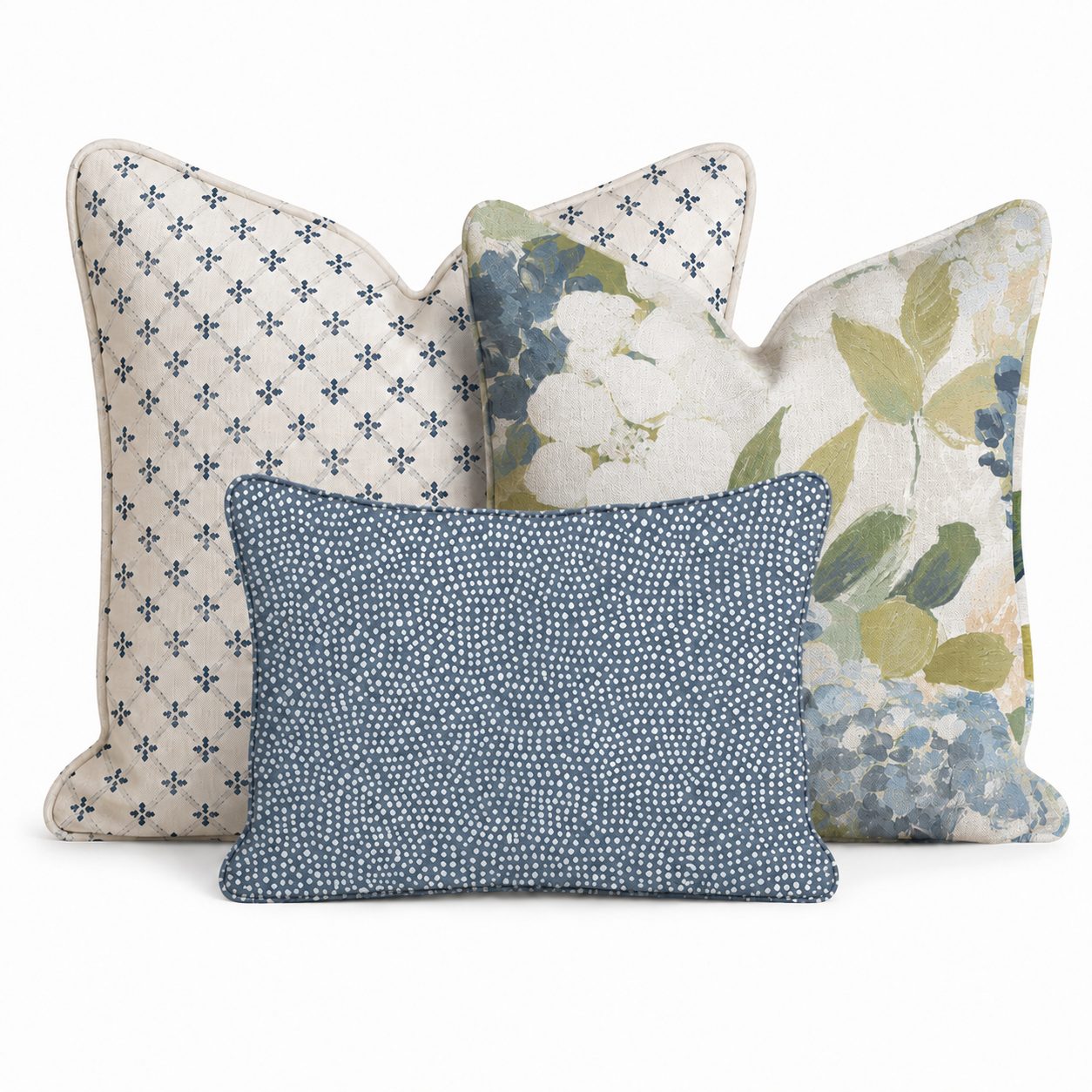 The Hillcroft Home Birdie Floral Trio Throw Pillow Bundle features three decorative pillows: one with a blue diamond pattern, another with a blue and green floral design, and a smaller front pillow in dark blue and white dots, all set against a crisp white background.