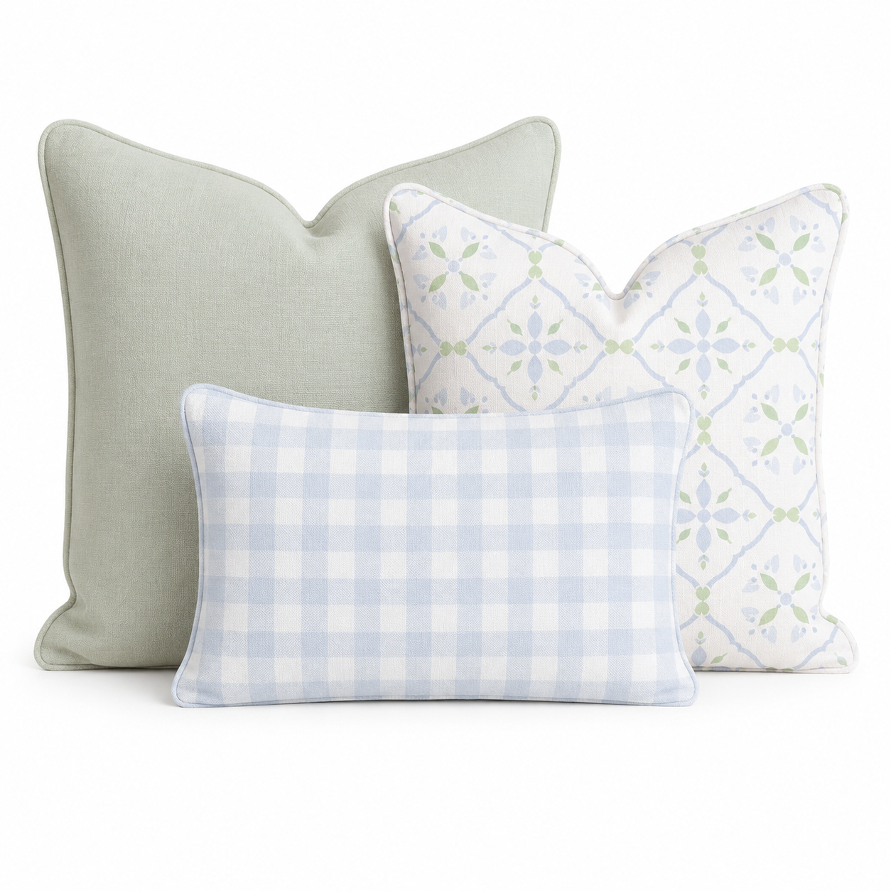 The Hillcroft Home Coastal Palms Block Trio Throw Pillow Bundle, featuring three decorative pillows—one solid light green, one with a white and green floral pattern, and one rectangular pillow with a light blue and white gingham check—is arranged against a white background.