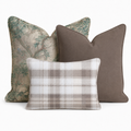 The Hedgerow Trio Throw Pillow Bundle by Hillcroft Home features three decorative pillows—one with a green floral pattern, one solid brown, and one in a beige and gray plaid design—arranged together against a plain white background.
