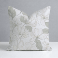 The Hillcroft x Lemon Park - Tangled Throw Pillow by Hillcroft Home is a square pillow with a white background, adorned with a delicate floral pattern in soft gray and green tones. Expertly crafted in the USA from a linen blend, this throw pillow features elegantly outlined flowers and leaves in light colors for a minimalist and refined design.